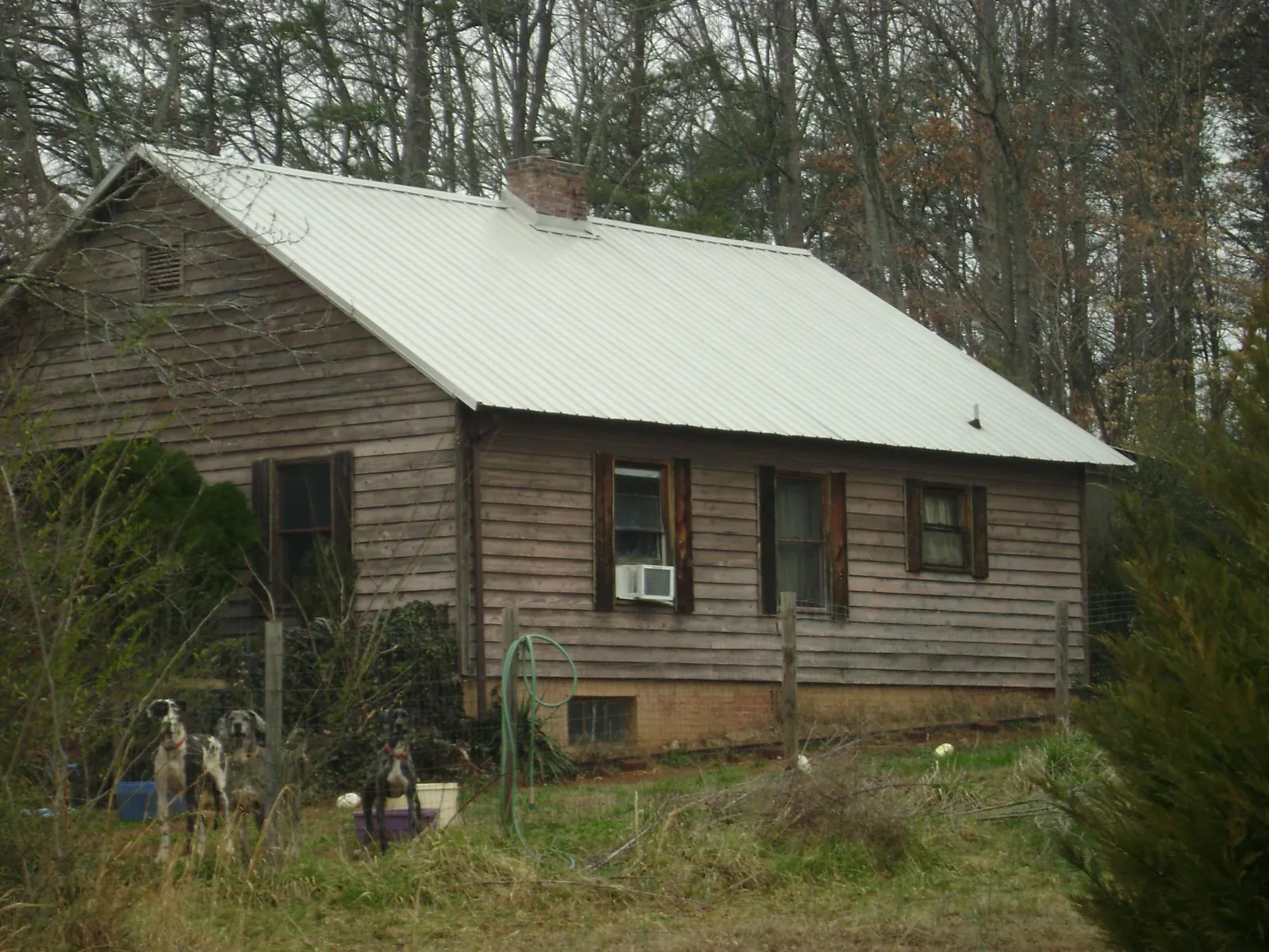 White metal roof on an old wood sided farmhouse, from a Metal Roof Installation job in Adrian